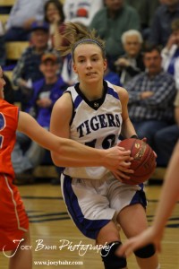 St. John Lady Tiger Jamie Waters (#12) drives into the the Otis-Bison Lady Cougar defense at St. John High School in St. John, Kansas on February 21, 2012.  Photo: Joey Bahr