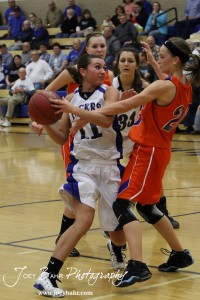 Morgan Osborne (#11) of the St. John Lady Tigers tries to pass the ball around the defense of Hannah Bannister (#23) of the Otis-Bison Lady Cougars at St. John High School in St. John, Kansas on February 21, 2012.  Photo: Joey Bahr