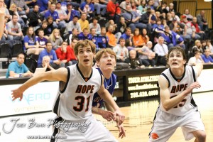 2012 Class 1A Division II Boys State Championship Semifinals Otis-Bison Cougar Patrick Piper (#22) watches the basketball as Hope Lions Dwight Davidson (#31) and Shilo Goracke (#25) move for a possible rebound in the 2012 Class 1A Division II Boys State Championship Semifinals Game at Gross Memorial Coliseum at Fort Hays State University in Hays, Kansas on March 9, 2012. Photo: Joey Bahr