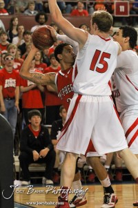 McPherson Bullpup Jordan Hart (#23) drives into the defense of Connor Goedert (#15) and other Ottawa Cyclones in the 2012 Class 4A Boys State Championship Quarterfinals Game at Salina Bicentennial Center in Salina, Kansas on March 8, 2012.  Photo: Joey Bahr