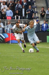 Sporting_KC_vs_LA_Galaxy_4-7-12_0790 LA Galaxy Midfielder Landon Donovan (#10) tries to hold back Sporting Kansas City Defender Seth Sinovic (#16) at LIVESTRONG Sporting Park in Kansas City, Kansas on April 7, 2012. (Photo: Joey Bahr, www.joeybahr.com)