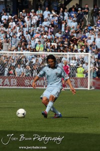 Sporting_KC_vs_LA_Galaxy_4-7-12_0897 Sporting Kansas City Midfielder Roger Espinoza (#15) kicks the ball against LA Galaxy at LIVESTRONG Sporting Park in Kansas City, Kansas on April 7, 2012. (Photo: Joey Bahr, www.joeybahr.com)